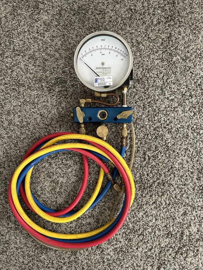 Backflow testing gauge with red, yellow and blue hoses